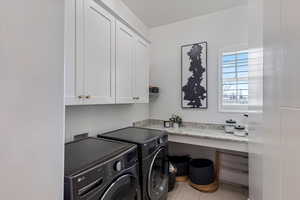 Laundry area featuring cabinet space, washing machine and clothes dryer, and tile patterned floors