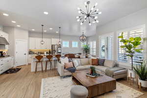 Living area featuring a chandelier, light wood-style flooring, and recessed lighting