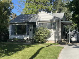 Bungalow featuring a front lawn and a shingled roof