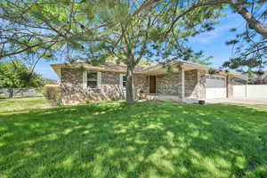 Ranch-style home featuring brick siding, an attached garage, and concrete driveway