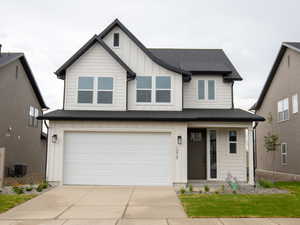 View of front of house with board and batten siding, concrete driveway, a garage, a porch, and roof with shingles