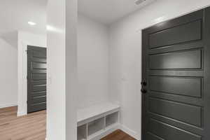 Mudroom with wood finished floors and recessed lighting