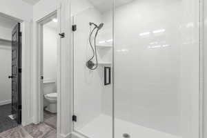 Bathroom featuring a shower stall and toilet