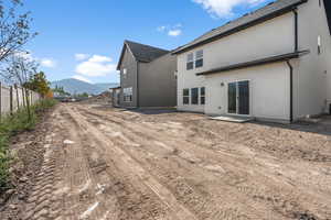 Back of house featuring a mountain view and stucco siding