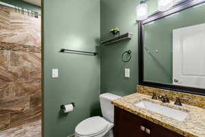 Bathroom featuring a tile shower and vanity