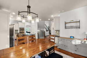 Dining space featuring wood finished floors, arched walkways, stairs, and recessed lighting