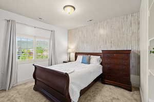 Carpeted bedroom featuring an accent wall and wooden walls