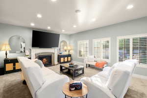 Living room with light colored carpet, recessed lighting, and a tile fireplace
