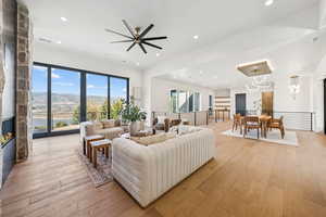 Living room featuring recessed lighting, light wood-type flooring, a mountain view, and a large fireplace