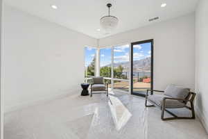 Sitting room featuring a mountain view, light colored carpet, recessed lighting, and a chandelier