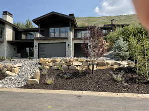 View of front of home featuring stone siding and a balcony