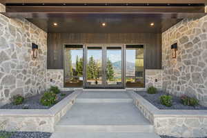 Doorway to property with stone siding, french doors, and a mountain view