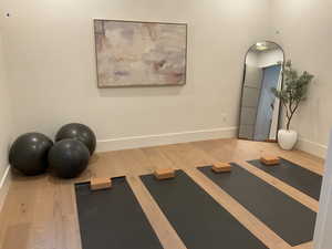 Workout room with baseboards and wood finished floors