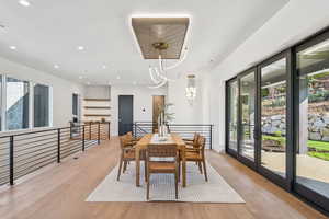 Dining space with healthy amount of natural light, recessed lighting, light wood finished floors, and a chandelier