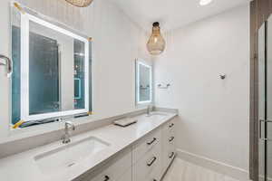 Bathroom with double vanity, light tile patterned flooring, recessed lighting, and tiled shower