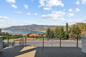Balcony featuring a water and mountain view