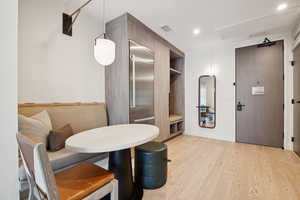 Dining area with light wood-style floors, recessed lighting, and attic access