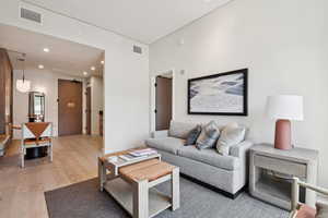 Living area featuring light wood-style floors and recessed lighting