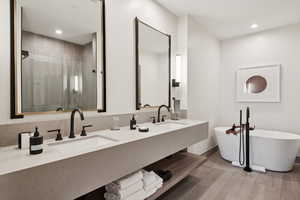 Full bath with a freestanding bath, double vanity, recessed lighting, and a shower stall