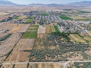 Aerial view of property and surrounding area featuring a mountainous background and rural landscape