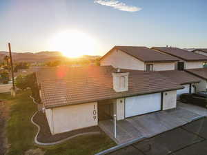View of front of house featuring stucco siding, driveway, an attached garage, and a tile roof