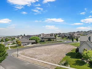 View of asphalt road featuring a residential view, curbs, and sidewalks