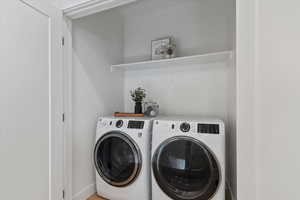 Washroom with washing machine and clothes dryer and baseboards
