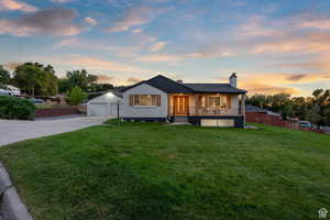 Bungalow-style home featuring a chimney, concrete driveway, an attached garage, and french doors