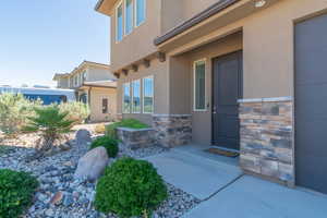 View of exterior entry featuring stucco siding and stone siding