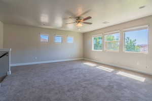 Carpeted empty room featuring ceiling fan and a textured ceiling