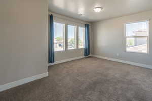 Carpeted empty room with baseboards and a textured ceiling