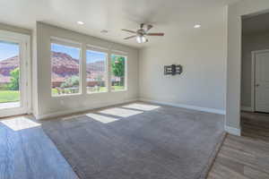 Spare room with a mountain view, ceiling fan, recessed lighting, and wood finished floors