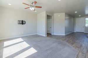 Unfurnished room featuring recessed lighting, ceiling fan, wood finished floors, and carpet floors