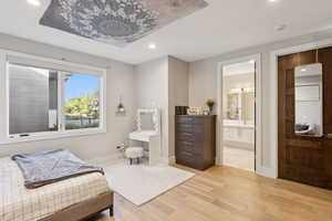 Bedroom featuring light wood-style flooring, recessed lighting, and ensuite bathroom
