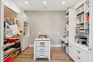 Office area with light wood finished floors and recessed lighting