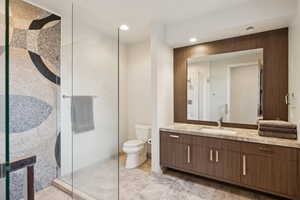 Bathroom featuring a walk in shower, vanity, and recessed lighting