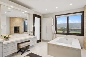 Bathroom featuring vanity, recessed lighting, a mountain view, a fireplace, and tile patterned floors