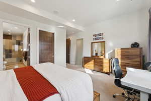Bedroom featuring recessed lighting, a desk, light colored carpet, and ensuite bathroom
