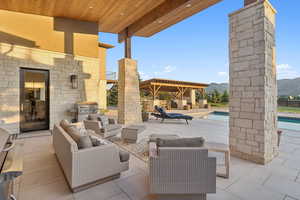 View of patio / terrace with area for grilling, a mountain view, and outdoor lounge area
