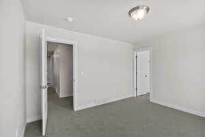 Carpeted empty room featuring baseboards