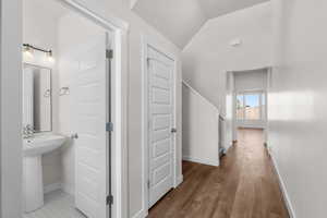 Hall featuring vaulted ceiling and wood finished floors
