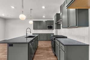 Kitchen with dark countertops, stainless steel appliances, backsplash, a textured ceiling, and dark wood-style flooring