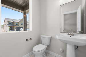Half bathroom with toilet and baseboards
