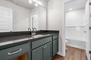 Full bath featuring vanity, wood finished floors, and shower / bathtub combination