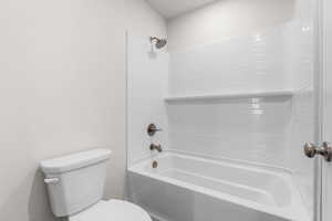 Full bath featuring toilet and shower / bath combination