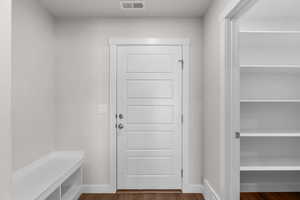 Mudroom with dark wood finished floors and baseboards