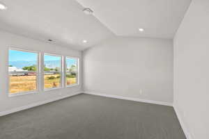 Primary bedroom with lofted ceiling, dark colored carpet, a textured ceiling, a mountain view, and recessed lighting