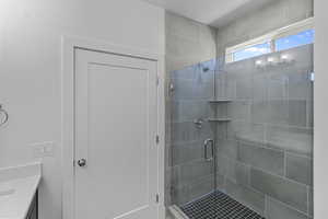Bathroom with a shower stall and vanity