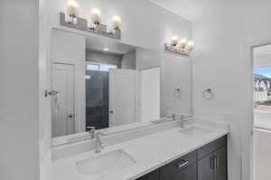 Bathroom with double vanity and a tile shower