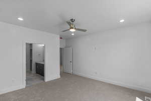 Primary Bedroom featuring light carpet, recessed lighting, and ensuite bath